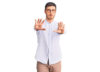 Fototapeta premium Handsome young man with bear wearing elegant business shirt and glasses doing stop gesture with hands palms, angry and frustration expression