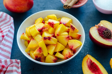 Chopped peaches and whole peache on a  table,  closeup.