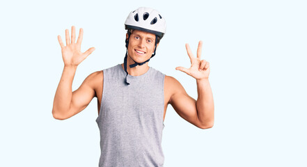 Naklejka premium Young handsome man wearing bike helmet showing and pointing up with fingers number eight while smiling confident and happy.