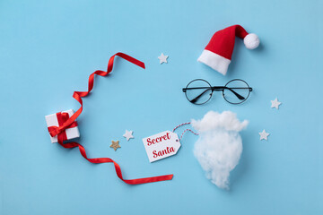 Christmas present or gift for Secret Santa with Santa hat, glasses and beard on blue background.