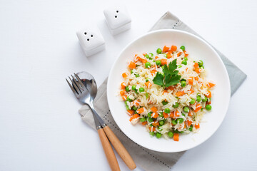 Boiled rice with vegetables on a plate, traditional Asian dish