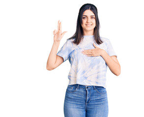 Obraz na płótnie Canvas Young beautiful girl wearing casual t shirt smiling swearing with hand on chest and fingers up, making a loyalty promise oath