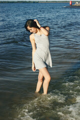 Happy woman in the water on the  sea shore in sunny weather.