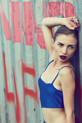 Attractive brunette girl in blue silk dress. Concept fashion photo. Selective focus.