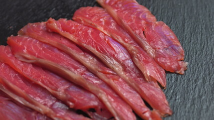 Close up shot of smoothly rotating salmon, Sushi cooking process - Philadelphia, burning fire smoking fresh raw red tuna salmon eel
