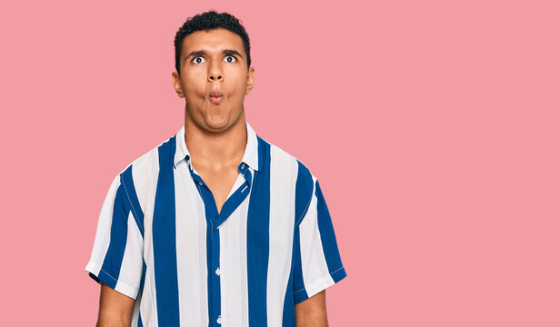 Young arab man wearing casual clothes making fish face with lips, crazy and comical gesture. funny expression.