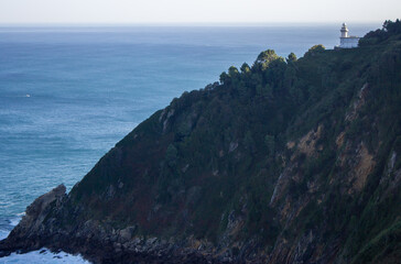 White lighthouse on the cliff, Bay of Biscay, Spain. Lighthouse on scenic seacoast. Aerial view of...