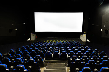 Cinema theater interior with screen and blue seats. Wide shot view from the back of an empty...