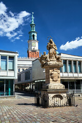 Fototapeta premium The historic figure of St. John of Nepomuk and the town hall tower in the market square