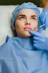 Surgeon does plastic opertation lips augmentation using filler in medical clinic for attractive...