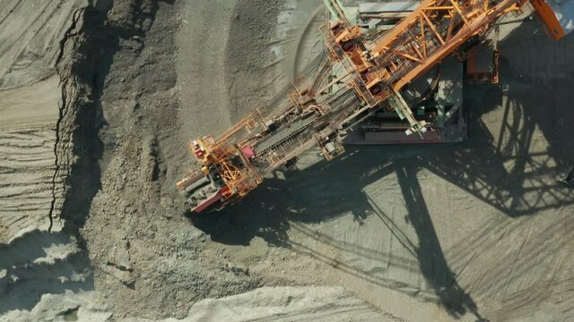 Aerial view of bucket wheel excavator in process of mining natural resource. Heavy industry.