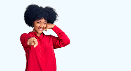 Young african american girl wearing casual clothes smiling doing talking on the telephone gesture and pointing to you. call me.