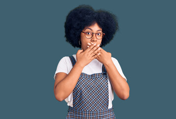 Young african american girl wearing casual clothes shocked covering mouth with hands for mistake. secret concept.