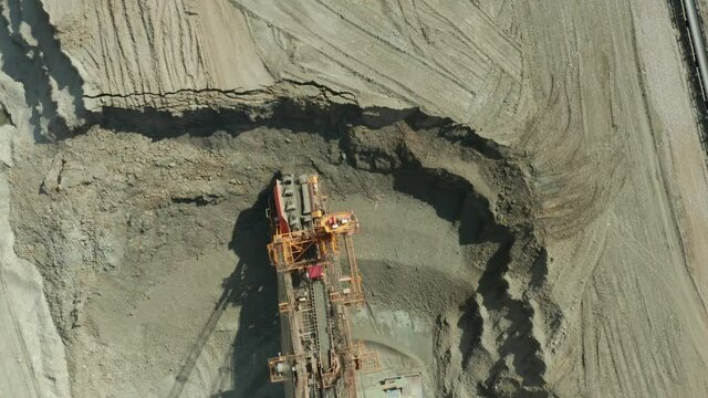 Aerial view of bucket wheel excavator in process of mining natural resource. Heavy industry.