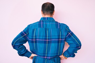 Young handsome man wearing casual clothes standing backwards looking away with arms on body