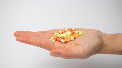 Colored painkillers capsules and tablets on the palm
