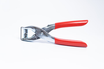 Red rivet puncher, riveting pliers close-up on a white background. Puncher and grommet installer. Tool for installing the eyelet. Isolated object