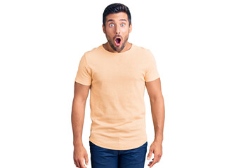 Fototapeta premium Young hispanic man wearing casual clothes afraid and shocked with surprise expression, fear and excited face.