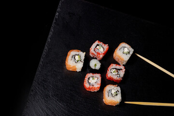 Philadelphia roll with salmon, cheese and cucumber on a black background. Sushi Philadelphia