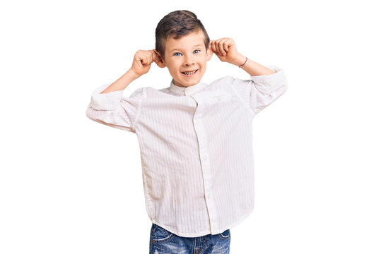 Cute Blond Kid Wearing Elegant Shirt Smiling Pulling Ears With Fingers, Funny Gesture. Audition Problem