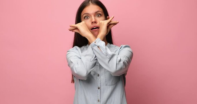 happy young casual woman in blue denim shirt making bla bla bla gesture, talking and making funny faces on pink background