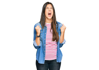 Young brunette woman wearing casual clothes angry and mad screaming frustrated and furious, shouting with anger. rage and aggressive concept.