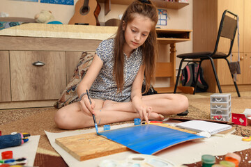 girl draws at home, artistic creation, makes creative artwork from paper, paints and brushes