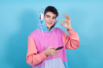 teenager boy with mobile phone and headphones isolated on background