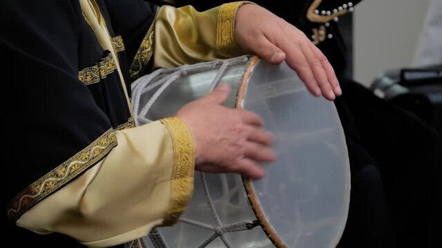 Slow motion: man hands playing ethnic azerbaijani percussion drum nagara on stage of summer open air concert - close up view. Entertainment, music, culture, leisure time and art concept