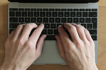 fingers on a laptop, typing