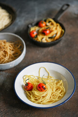Italian pasta spaghetti with grilled tomato on the plates on the rustic background. Vegetarian food, vitamin.