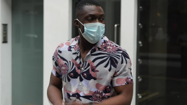 Black male coughing through face mask 