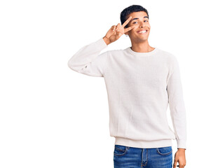 Young african amercian man wearing casual clothes doing peace symbol with fingers over face, smiling cheerful showing victory