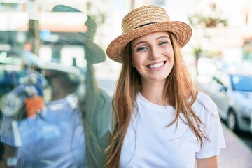 Young blonde woman on vacation smiling happy leaning on the wall at street of city