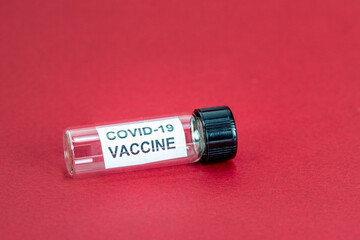 Coronavirus Covid-19 Vaccine Bottle on red background