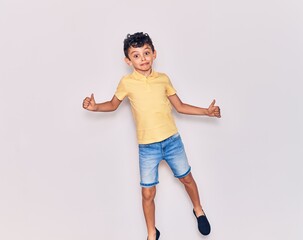 Adorable kid wearing casual clothes jumping over isolated white background