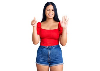 Obraz na płótnie Canvas Young beautiful asian girl wearing casual clothes showing and pointing up with fingers number six while smiling confident and happy.