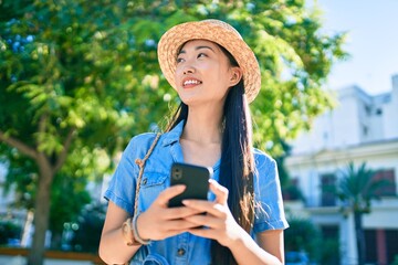 Fototapeta premium Young chinese tourist woman using smartphone at street of city.