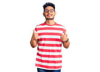 Handsome latin american young man wearing casual clothes and glasses success sign doing positive...