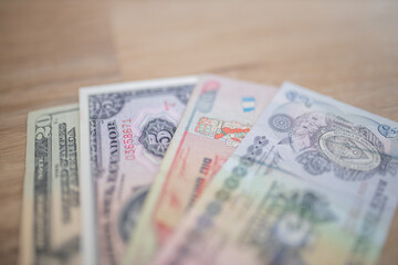 Twenty-Dollar, Five Sucres, Ten Quetzales, and Five Lempiras Bills on a Table