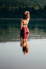 Woman standing in the lake, golden hour