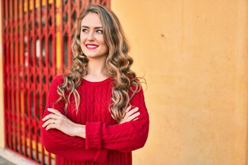 Young blonde girl smiling happy walking at the city.