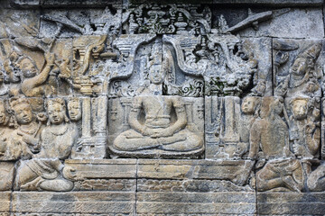 A stone wall relief depicting a king and his subjects at Candi Borobudur the largest Buddhist temple in the world.