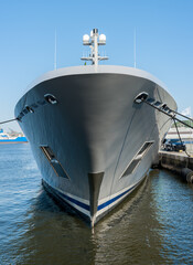 The bow of a grey yacht at port..