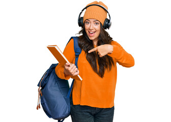 Beautiful brunette young woman wearing student backpack and holding books smiling happy pointing with hand and finger