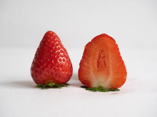 Close up of fresh strawberries - one of them is cut in half
