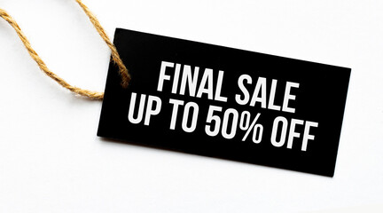 FINAL SALE UP TO 50 percents text on a black tag on a white paper background