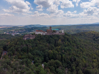 Aerial view of Castle Wartburg with forest in the foreground a blue sky with clouds in the background
