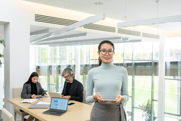 Successful young pretty Asian businesswoman in eyeglasses and casualwear