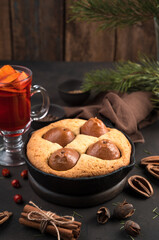 Christmas table with pear pie and mulled wine on a brown background. Side view, vertical orientation. The concept of new year and Christmas.